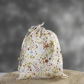 A large hygiene draw-string bag with colorful stars print, displayed on a woo Foto stock