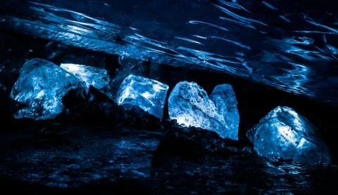 Large ice blocks lit up within an ice cave deep inside the Spencer Glacier in Stock Photos