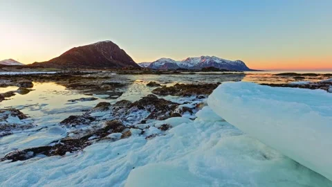 Large Ice Chunk on an Arctic Shoreline Beneath Snowy Peaks Stock-Footage 341644957