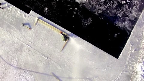 Large ice cubes are sawn of the ice cover of a frozen lake, vertical aerial shot Stock Footage 72790311