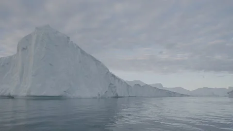 A Large Iceberg and Cloudy Skies From a Boat 2 Stock Footage 292939775