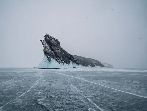 A large iceberg is majestically floating in the middle of a frozen lake Stock Photos