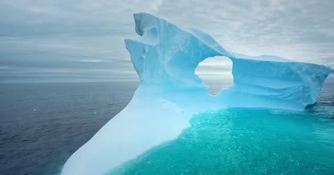 Large iceberg with melted hole float arctic ocean Stock Photos