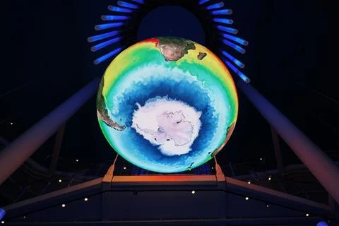 A large illuminated digital Earth globe displays Antarctica and surrounding Stock Photos