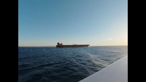 Large industrial cargo ship sailing across the blue ocean during a beautiful Stock-Footage 334715699