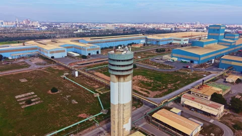 Large industrial complex with a control tower and multiple buildings in a clear Stock Footage 331155474