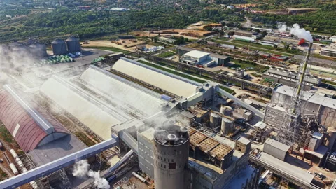 Large industrial complex with multiple buildings and smoke coming from stacks in Stock Footage 341381728