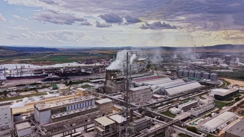 Large industrial complex with smoke and clouds over landscape Stock Footage 339650040