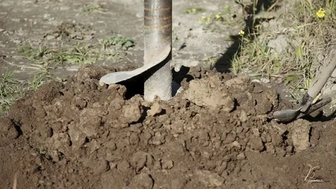 A large industrial drill screw gradually enters the ground Stock Footage 85299588