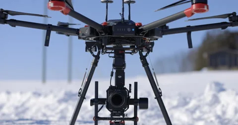 Large industrial drone with camera prepares for lift off in winter snow - close  Video stock 148223239