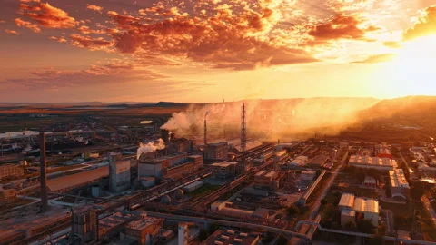 Large industrial facility under the sky colored orange at sunset. Drone footage Stock Footage 340856910