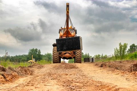 A large industrial loader equipped with a crane mounted on top, ready for hea Stock Photos