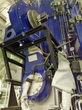 Large Industrial Machine with Blue Casing and Metal Frame Indoors Stock Photos