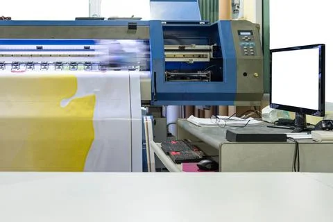 Large inkjet printer working on vinyl banner with computer screen Stock Photos