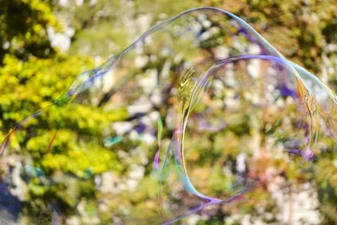 Large iridescent soap bubbles of different sizes on the streets of the city.  Stock Photos
