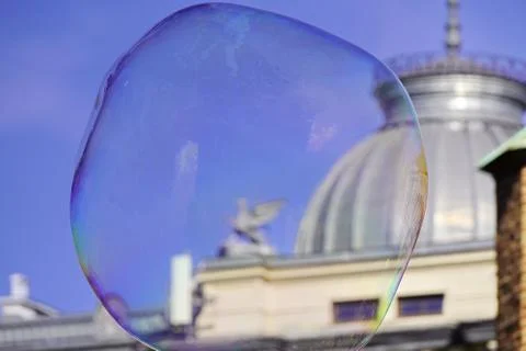 Large iridescent soap bubbles of different sizes on the streets of the city.  Foto stock