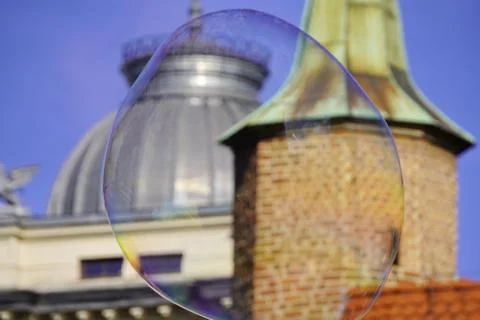 Large iridescent soap bubbles of different sizes on the streets of the city.  Stock Photos