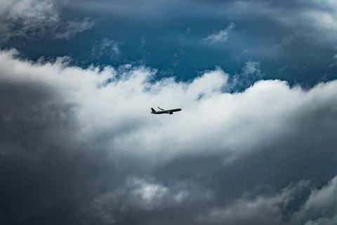 A large jet is flying through a cloudy sky 스톡 사진