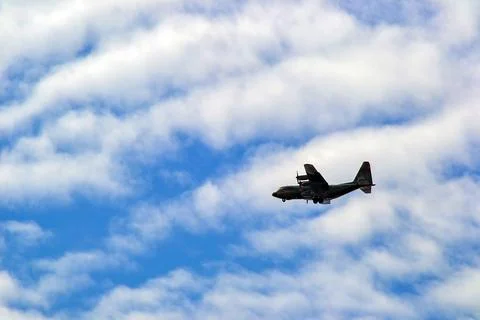 A large jet is flying through a cloudy sky Stock Photos