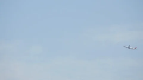 Large jet moving through the frame of blue sky Stock Footage 106592234