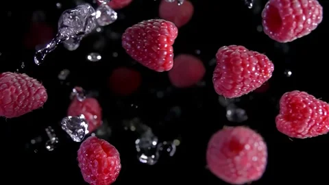 Large juicy appetizing raspberries bouncing with splashes of water Stock Footage 287447992