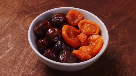 Large juicy dates and dried apricots in a bowl rotating in a circle. Medium.. Stock Footage 305937674