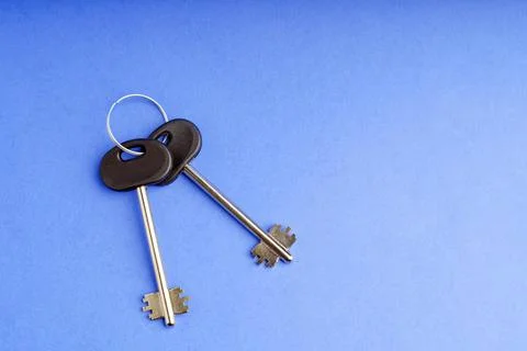 Large keys on a blue background with paper texture Stock Photos