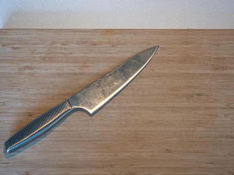 A large kitchen knife on a cutting board Stock Photos