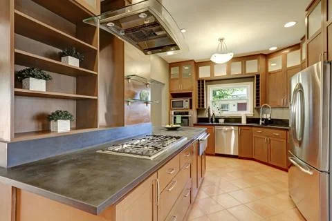 Large kitchen room interior with brown cabinets and modern stainless steel ap Stock Photos