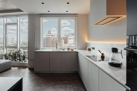 Large kitchen with unusual layout, light walls, large windows, many room plants Stock Photos