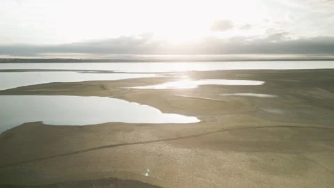 Large lake beach and sun reflecting in the water Video stock 254592589