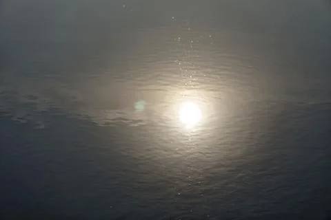 Large Lake with sun and cloud in reflection in disgusted sky Stock Photos