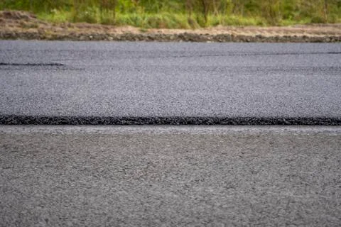 A large layer of fresh hot asphalt. Layer of asphalt raw material in a shallow Stock Photos