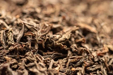 Large-leaved black tea in bulk on the table. Close-up of the surface texture Stock Photos