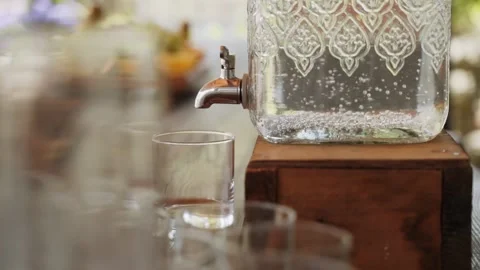 Large lemonade jar stands on wooden stand. Silver faucet of can, close-up. Stock Footage 170176232