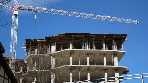 A large lifting construction crane stands near the house that is being erected. Video stock 346742746