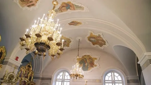 A large light chandelier hangs under the ceiling in an Orthodox Christian church Stock Footage 221200306