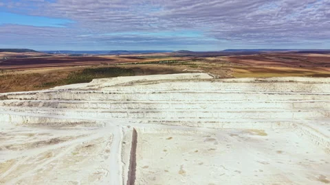 Large limestone quarry in operation with machinery moving rock and workers Stock Footage 345457163