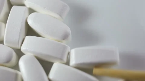 Large long tablets are counted with a wooden stick. On a white background, close Stock Footage 144643621