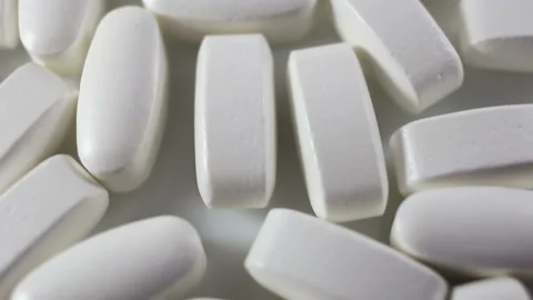 Large long tablets in a shiny shell move smoothly in the frame. White background Stock Footage 144643647
