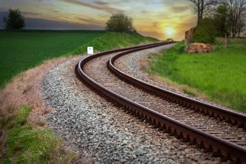 A large long train on a train track with trees in the background Stock Photos