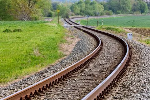 A large long train on a train track with trees in the background Stock Photos