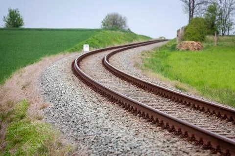 A large long train on a train track with trees in the background Stock Photos