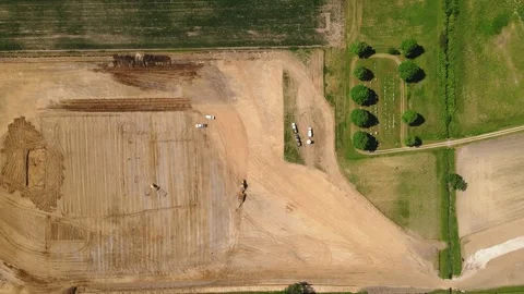 Large machine expertly lays pipes in a sprawling field. Stock Footage 259326508