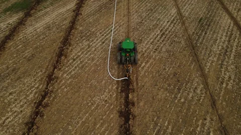 Large machine expertly lays pipes in a sprawling field. Stock-Footage 259326515