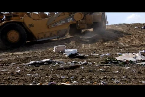 A large machinery moves through a garbage dump. Stock Footage 552355