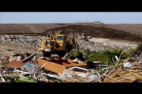 A large machinery moves through a garbage dump. Stock Footage 552356