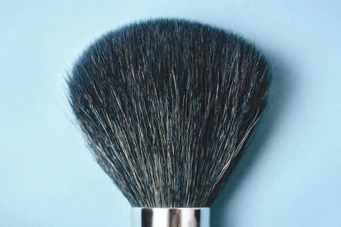 Large makeup brush on a blue background. Stock Photos