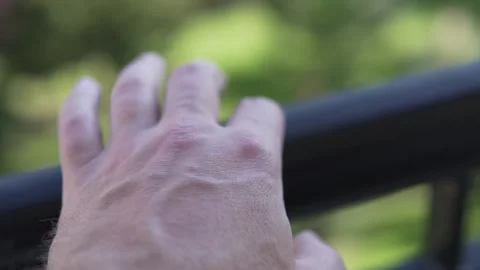 A large male hand nervously taps the railing of the balcony with his fingers Stock Footage 233145947