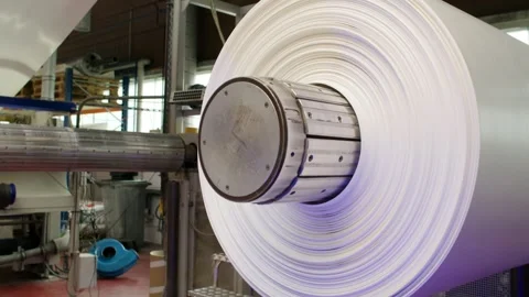 Large Material Roll Spinning Fast on Industrial Winder, Mill Hall, Medium Shot Stock Footage 341300109